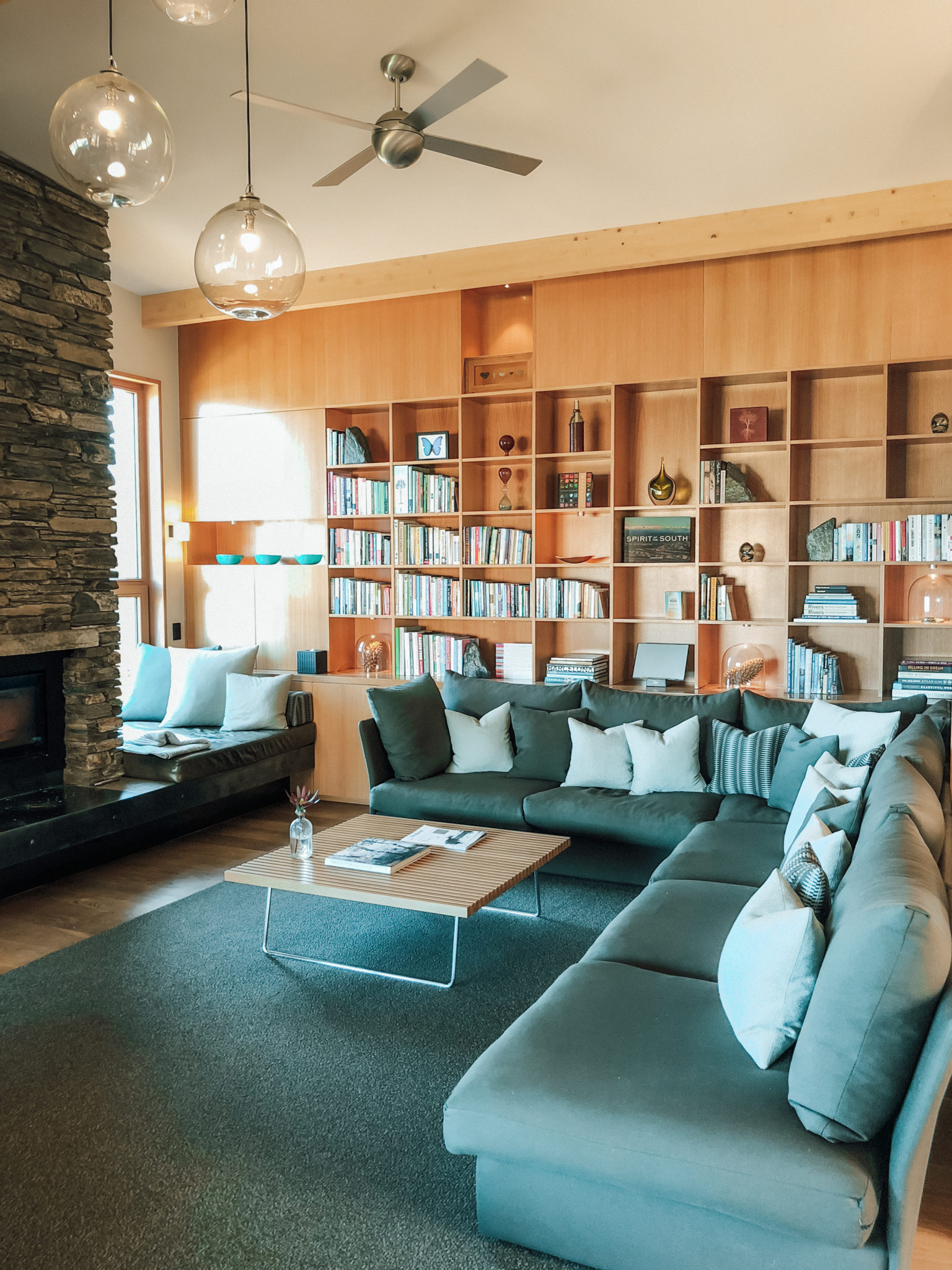 Library lounge with fireplace and bookshelves at Aro Hā wellness retreat
