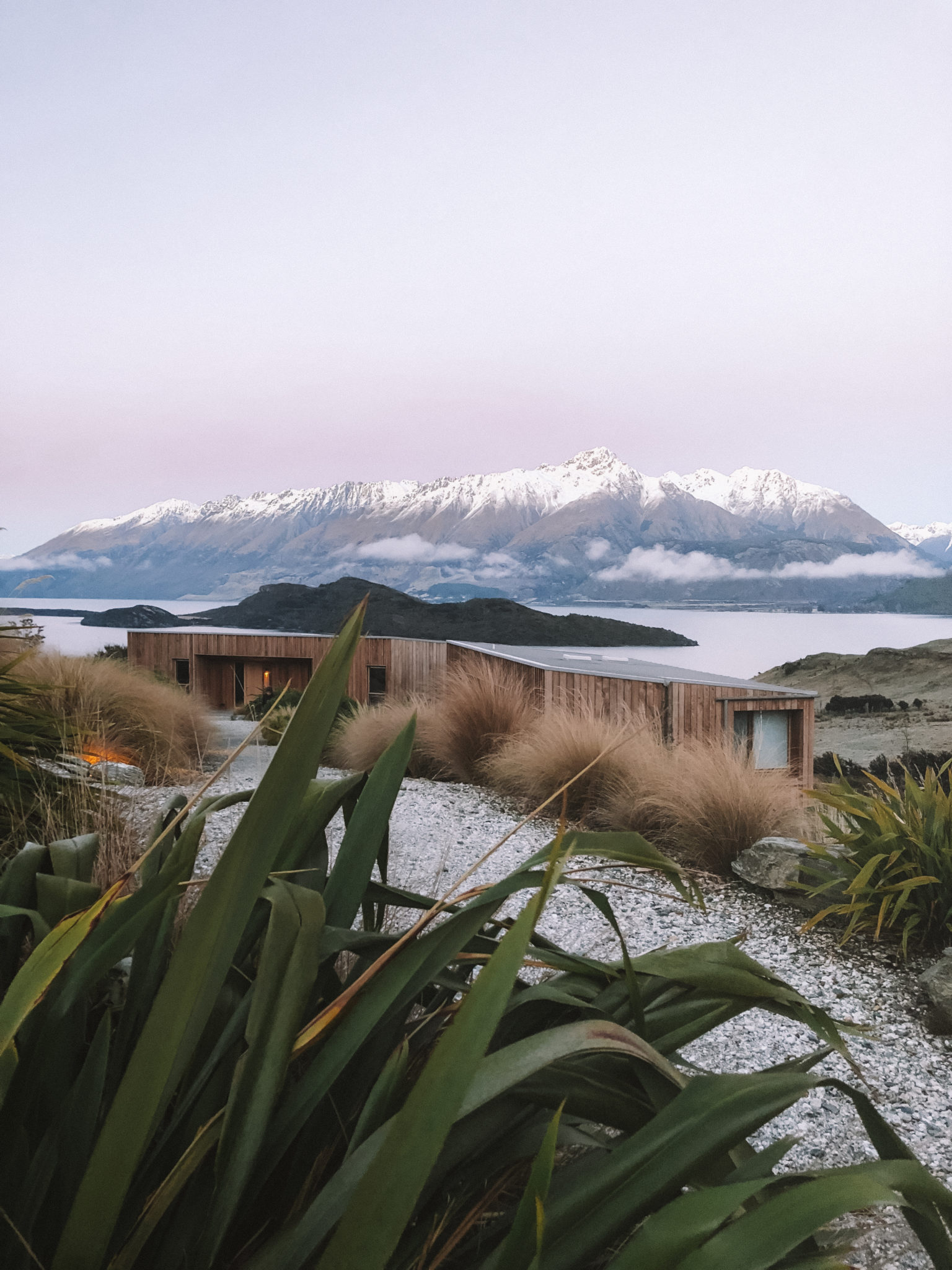 Aro Hā lodge above Lake Wakatipu framed by native flax